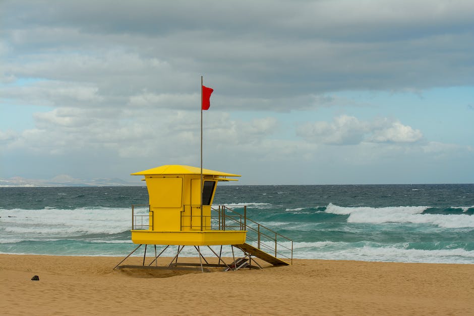 Die rote Flagge am Meer symbolisiert eine Gefahrenzone.